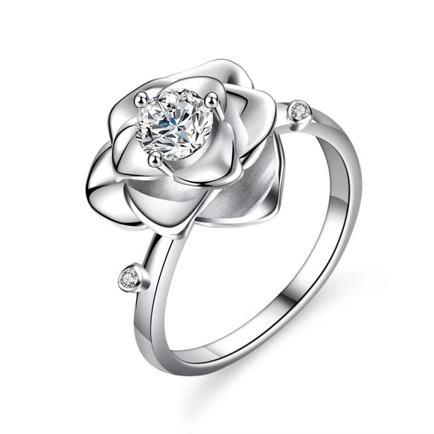 Close-up of elegant floral silver ring with diamond center stone and delicate petal design, symbolizing feminine elegance and timeless jewellery style.