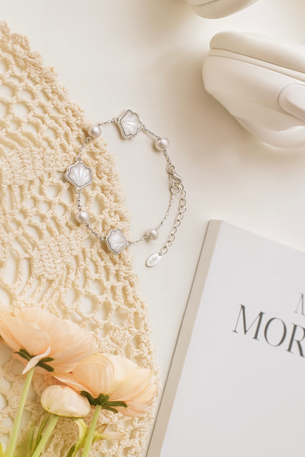 Sterling silver bracelet with pearl and mother-of-pearl shell charms styled with flowers – timeless elegant jewelry for women.